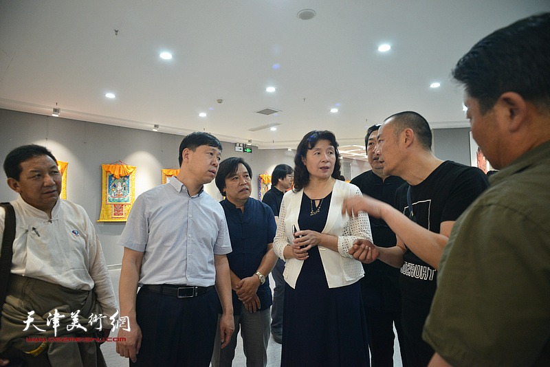 万镜明、张庆岩、李耀春与徐展在画展现场交流。