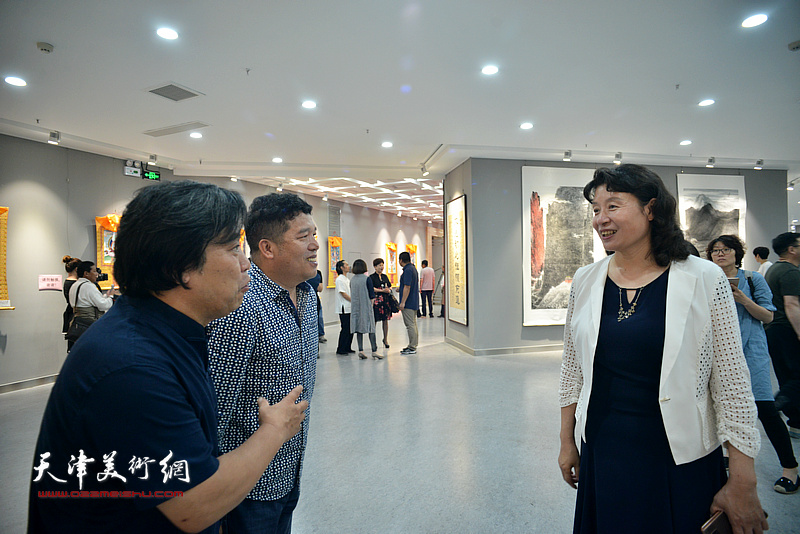 万镜明、李耀春、董克诚在画展现场交流。
